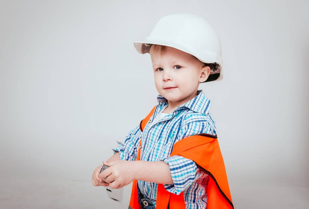 Little boy in helmet on white background. Construction, repair, interior. - Fotó, kép