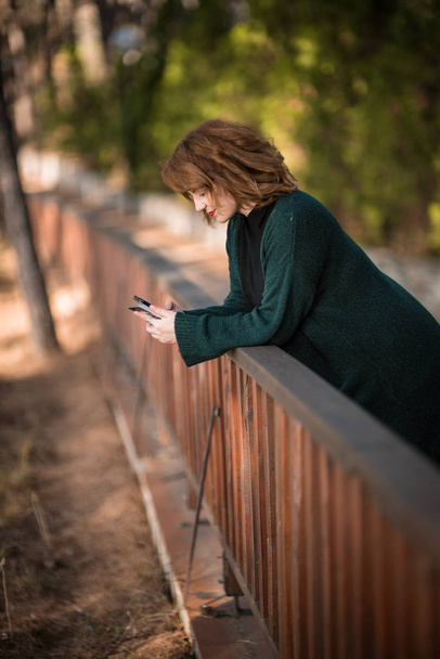 Woman with smartphone, at park - Foto, imagen
