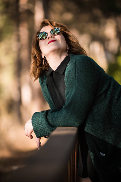 Mujer con gafas de sol posando en el parque
 - Foto, Imagen