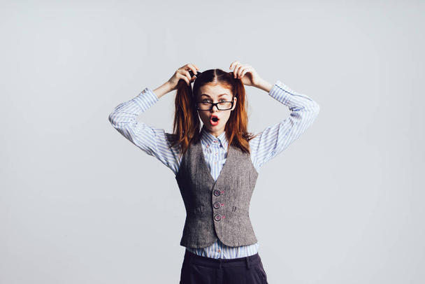 funny surprised red-haired schoolgirl with glasses touches her hair - Zdjęcie, obraz