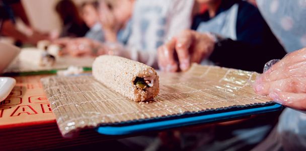 Children prepare sushi and rolls. Master-class in restaurant. - Foto, imagen