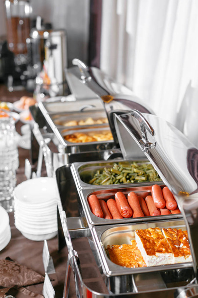 Muchas bandejas climatizadas buffet listo para el servicio. Desayuno en el hotel buffet de catering, envases de metal con comidas calientes
 - Foto, imagen