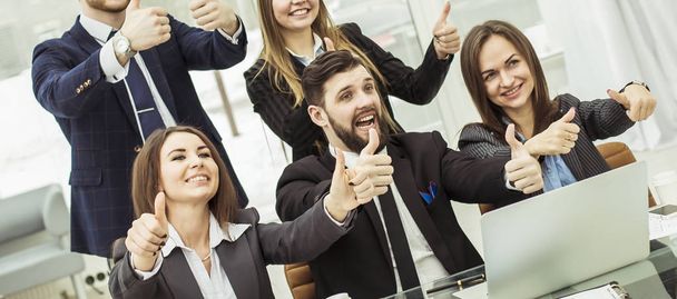 success concept in business - friendly business team makes a gesture of thumbs up - Foto, imagen