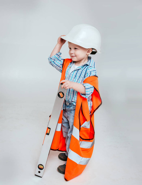 Little boy on the white background. Construction, repair, interior. - Фото, изображение