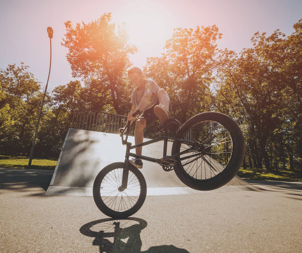 Young BMX rider performing tricks at skatepark. - Foto, Bild