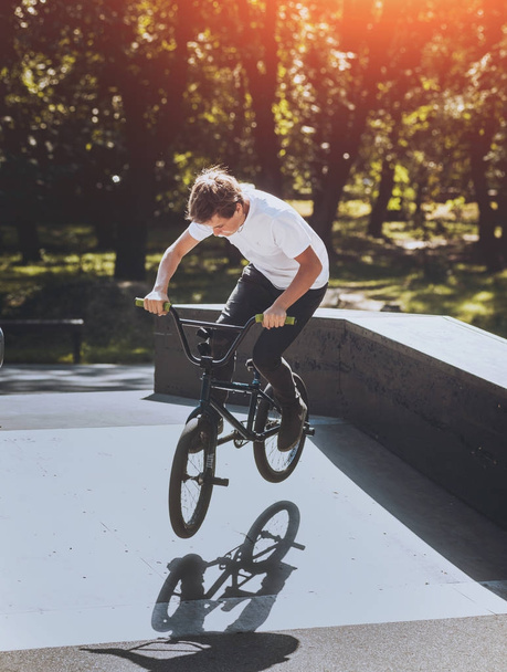 Young BMX rider performing tricks at skatepark. - Valokuva, kuva