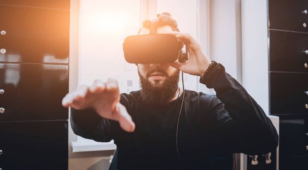 Young man wearing virtual reality goggles at the office. - Valokuva, kuva