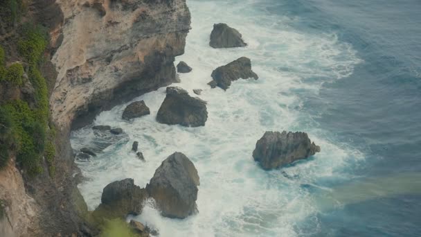 Des vagues océaniques se brisent sur les falaises de pierre. Vue aérienne de la plage tropicale Bali, Indonésie. Mouvement lent
 - Séquence, vidéo