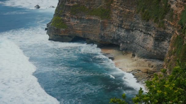 Okyanus dalgaları taş uçurumlarda kırma. Tropikal Beach Bali, Endonezya Hava üstten görünüm. Ağır çekim - Video, Çekim