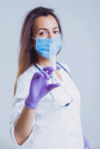 Young nurse or doctor in glasses with stethoscope against white wall - Foto, Imagem