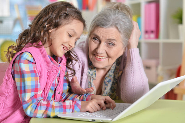 portrait of happy grandmother and daughter using laptop - Fotoğraf, Görsel