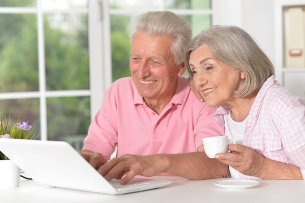 portrait of happy beautiful senior couple using laptop at home - Фото, зображення