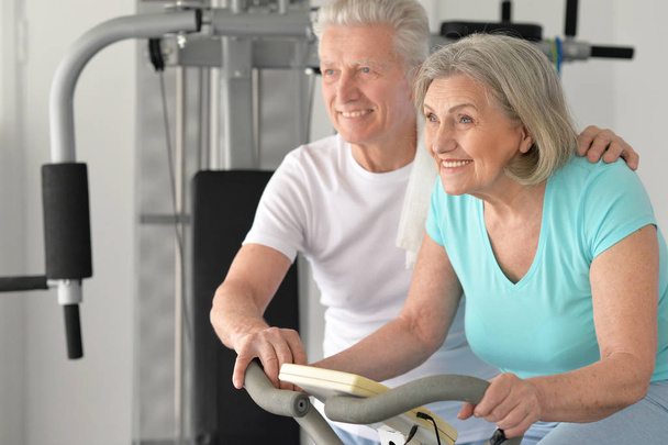 Active smiling senior couple exercising in gym - Photo, Image