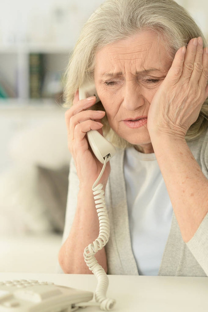 Sick mature woman calling doctor - Fotó, kép