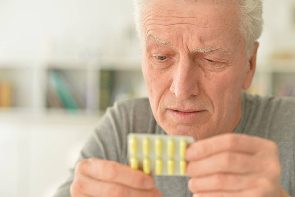 Elderly ill man with pills in hand - Foto, Imagem