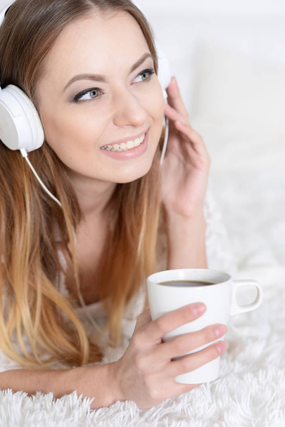 junge schöne Frau hört Musik zu Hause auf dem Sofa - Foto, Bild