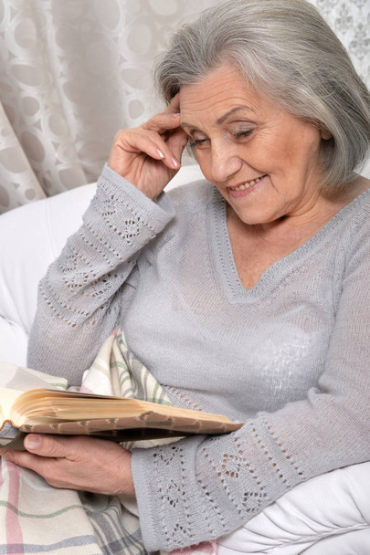 Senior woman with book at home - Фото, зображення