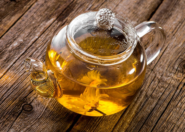 glass teapot with herbal tea close-up on wooden board background - Fotografie, Obrázek