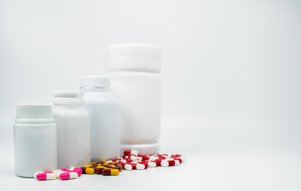 Αντιβιοτικό κάψουλες χάπια και πλαστικό μπουκάλι με κενή ετικέτα που απομονώνονται σε λευκό φόντο με αντίγραφο χώρου. Ναρκωτικών αντίσταση έννοια. Χρήση ναρκωτικών αντιβιοτικά με λογικές και καθολική αντίληψη υγειονομικής περίθαλψης. - Φωτογραφία, εικόνα