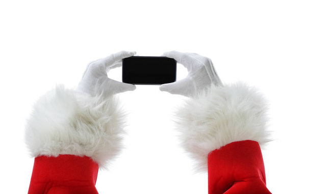 Christmas concept shot with Santa holding a black smart phone, showing it into the camera - Фото, зображення