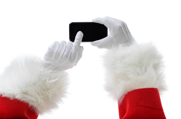 Christmas concept shot with Santa holding a black smart phone, showing it into the camera - Fotó, kép