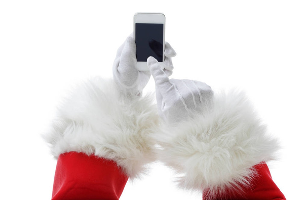 Concept de Noël tourné avec le Père Noël tenant un téléphone intelligent blanc isolé sur blanc
 - Photo, image