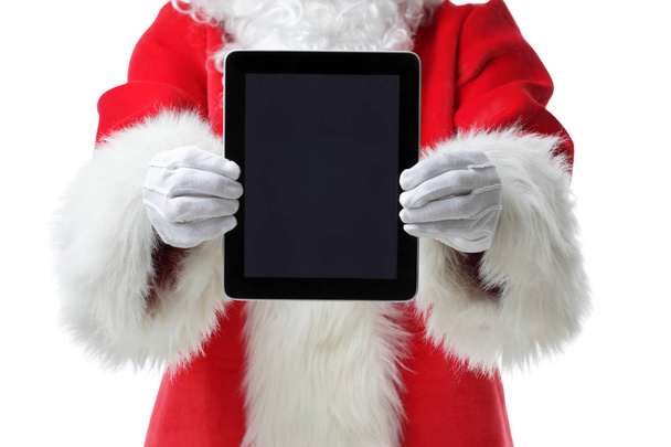 Christmas concept shot with Santa holding a digital tablet, showing it into the camera Isolated on white concept shot with Santa holding a digital tablet, show - Photo, image