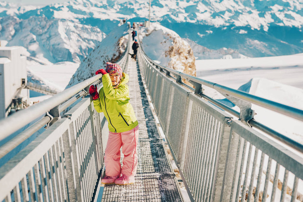 Dziecko dziewczynka bawi się śniegu na szczycie góry, zimowy urlop z dziećmi, atrakcje dla rodzin w Alpach. Obraz objšł Glacier 3000, kanton Vaud, Szwajcaria - Zdjęcie, obraz
