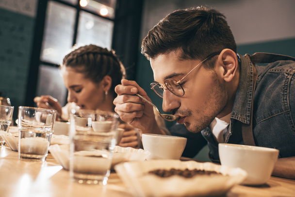 Trabajadores de cafeterías comprobando la calidad del café durante la función de café - Foto, imagen