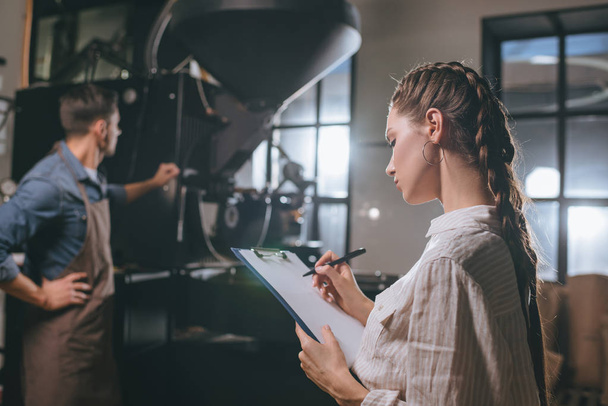 Вибірковий фокус жінка контрольне колег працювати під час кава випалу процес - Фото, зображення