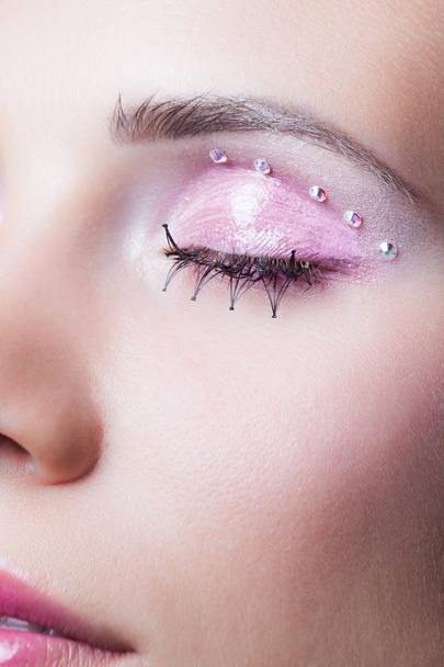 Közelkép a nő arcát, pink smink, szempilla és kristályok - Fotó, kép