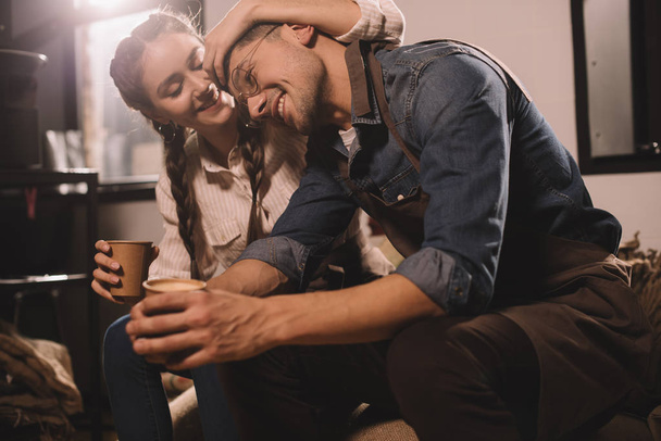 šťastný pár se šálky kávy mají přestávku během práce v kavárně - Fotografie, Obrázek