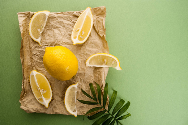 Lemons on kraft paper on a light green textured background - Fotografie, Obrázek