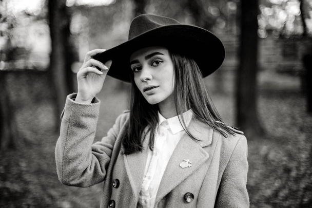 Attractive young woman in fashionable hat posing in autumnal park  - Foto, Imagen