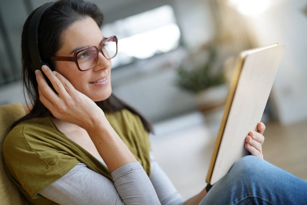Woman at home connected with tablet and headset - Foto, Imagen