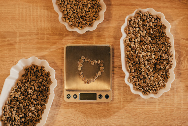 bovenaanzicht van regeling van kommen met koffiebonen voor voedsel functie en keuken schalen op houten tafelblad - Foto, afbeelding