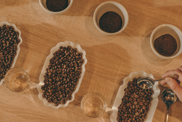 vlakke leggen met kommen van koffie en koffie bonen voor voedsel functie op houten oppervlak vermalen - Foto, afbeelding