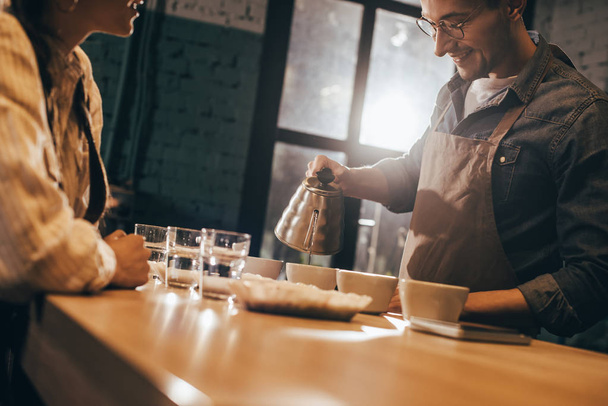 selective focus of smiling man pouring hot water into bowl with grind coffee - Photo, Image