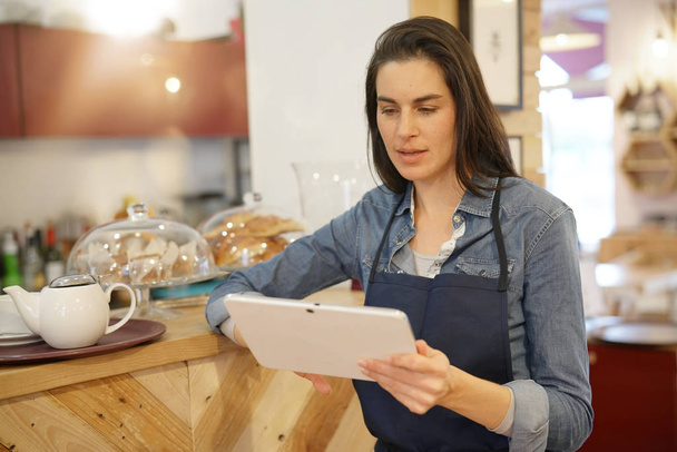Waitress in coffee shop taking order on digital tablet - Photo, image