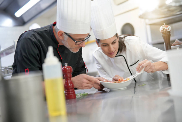 Professional cook chefs in kitchen improving dish composition - Photo, image