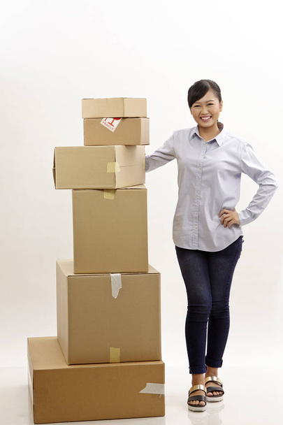 asian woman with stack of boxes on the white background - Zdjęcie, obraz
