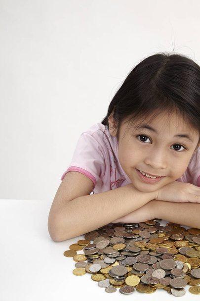little girl with coins on the table - Foto, imagen