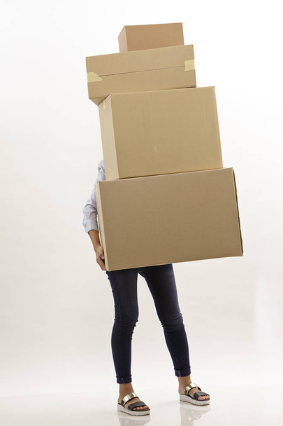 woman carring stack of brown boxes she hiding behind boxes - Foto, Imagem