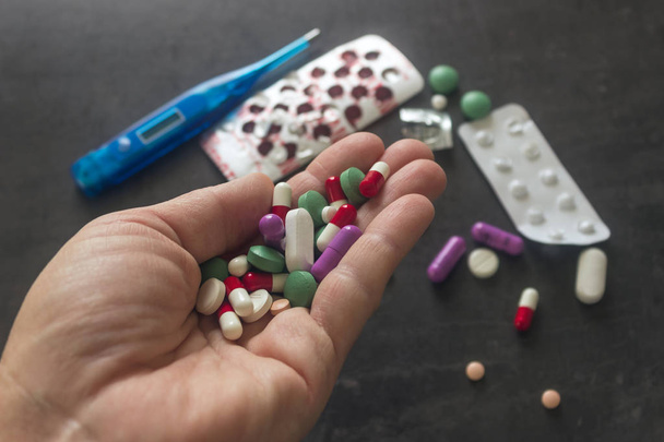 Coloridas pastillas y medicinas en la mano. Antecedentes farmacéuticos
.  - Foto, Imagen