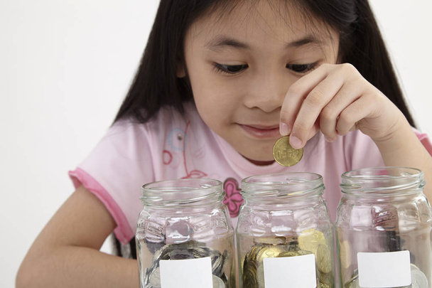 little with three saving jars with coins - Foto, Imagem