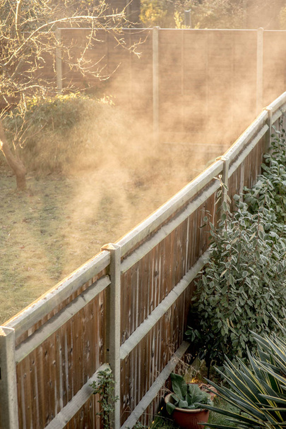 Manhã gelada fria com a elevação da névoa como degelo da geada
 - Foto, Imagem
