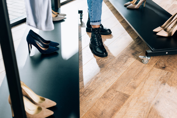Schnappschuss von Shopper in stylischen Stiefeln in Bekleidungsgeschäft - Foto, Bild