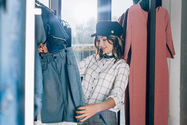 hermosa mujer joven en busca de ropa nueva en la tienda
 - Foto, Imagen