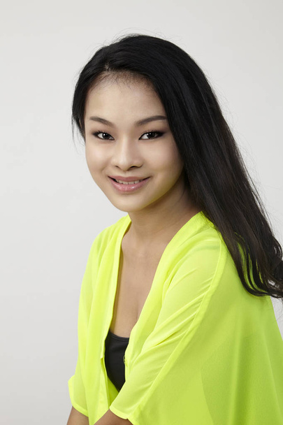 Asian woman smiling looking happy in yellow shirt - Zdjęcie, obraz