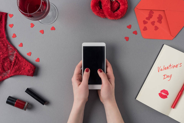 image recadrée de la femme tenant smartphone dans les mains, ordinateur portable avec des mots Saint Valentin
 - Photo, image